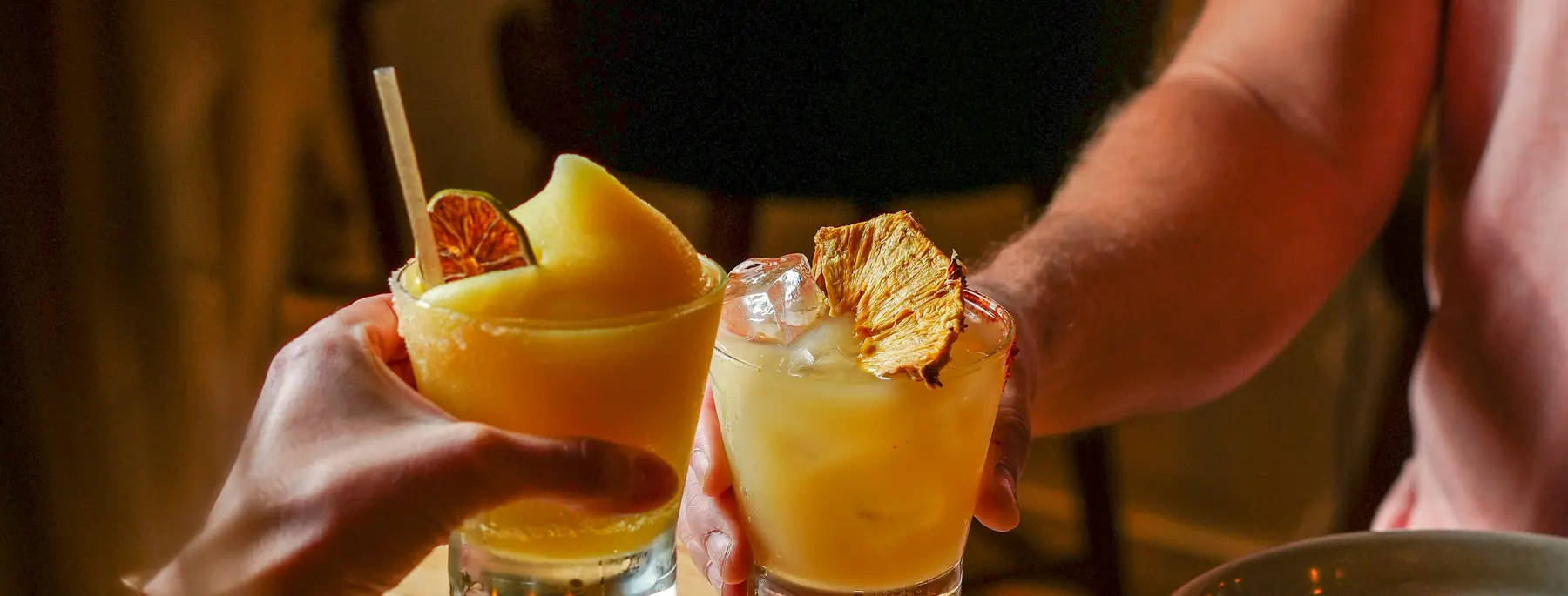 Two guests toasting cocktails at Avalon